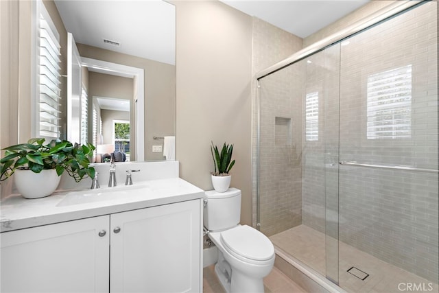 bathroom with walk in shower, vanity, and toilet