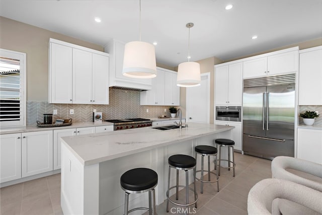 kitchen featuring pendant lighting, stainless steel built in refrigerator, premium range hood, and white cabinets