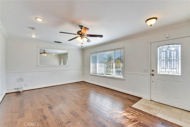 foyer entrance with hardwood / wood-style floors, crown molding, and ceiling fan