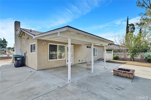 back of house with a patio area and a fire pit