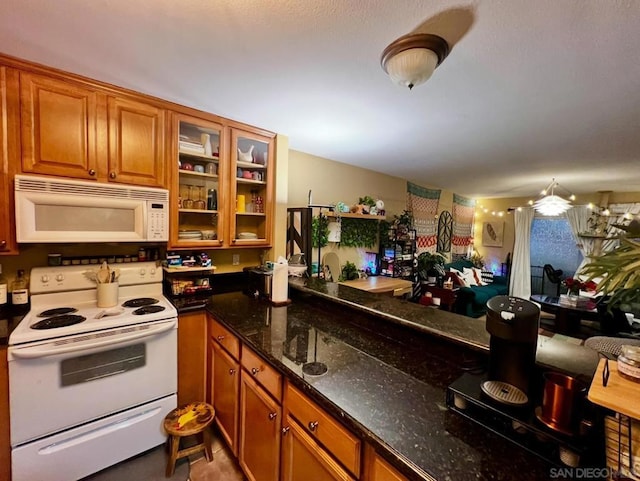 kitchen featuring dark stone countertops and white appliances