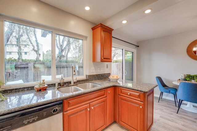 kitchen featuring sink, dishwasher, light hardwood / wood-style floors, stone countertops, and kitchen peninsula