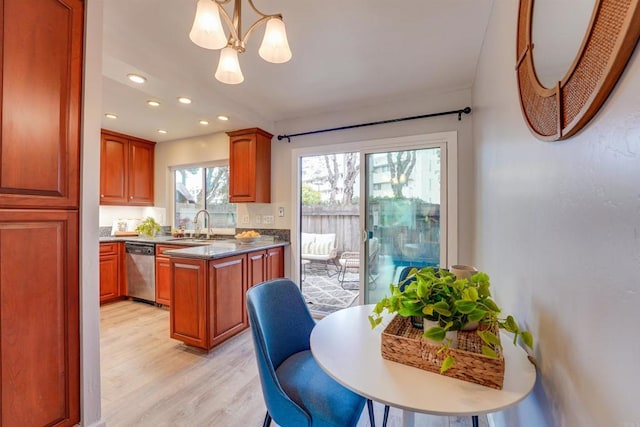 kitchen featuring sink, dishwasher, hanging light fixtures, light hardwood / wood-style floors, and a chandelier