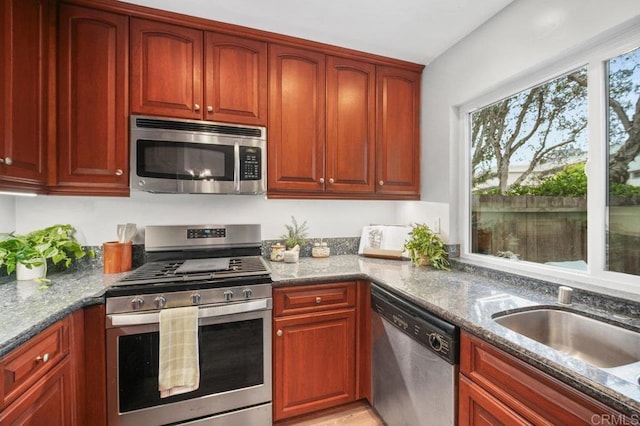 3575 Monair Dr Unit C, San Diego, CA 92117 - kitchen featuring appliances with stainless steel finishes, stone countertops, reddish brown cabinets, and a sink