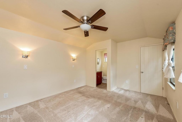 carpeted empty room featuring vaulted ceiling and ceiling fan