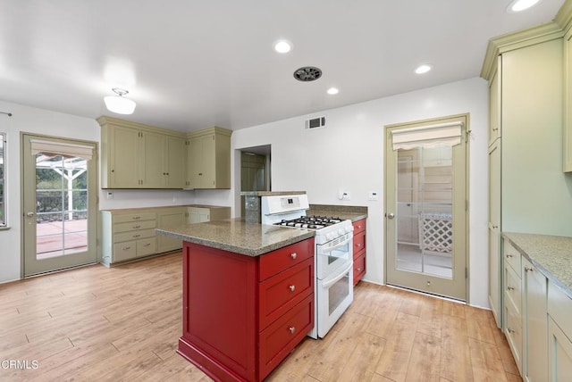 kitchen featuring double oven range, dark stone countertops, and light hardwood / wood-style floors