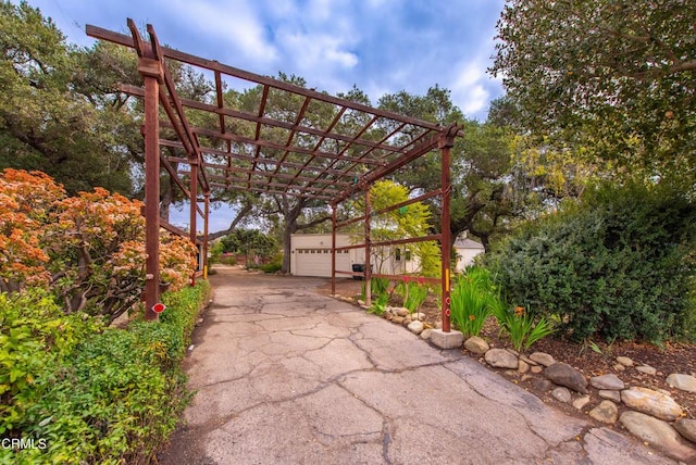 view of patio / terrace with a garage and an outbuilding