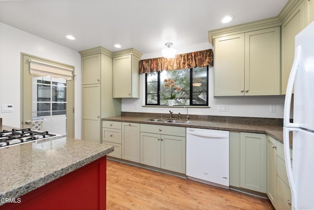 kitchen featuring sink, white appliances, and light hardwood / wood-style floors