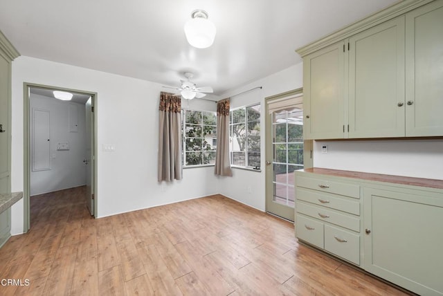 unfurnished dining area with ceiling fan and light hardwood / wood-style floors