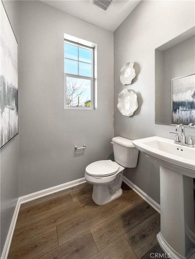 bathroom featuring hardwood / wood-style floors and toilet