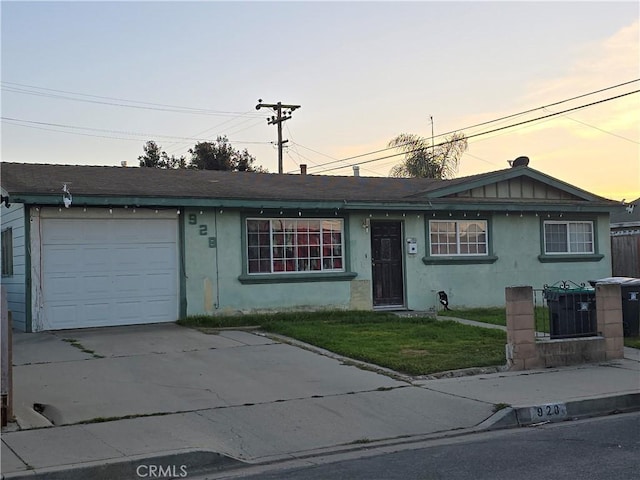 ranch-style home featuring a garage and a lawn