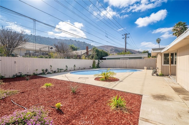 view of swimming pool featuring a mountain view and a patio