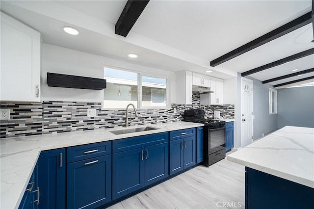 kitchen featuring sink, white cabinets, light stone counters, blue cabinetry, and black gas range