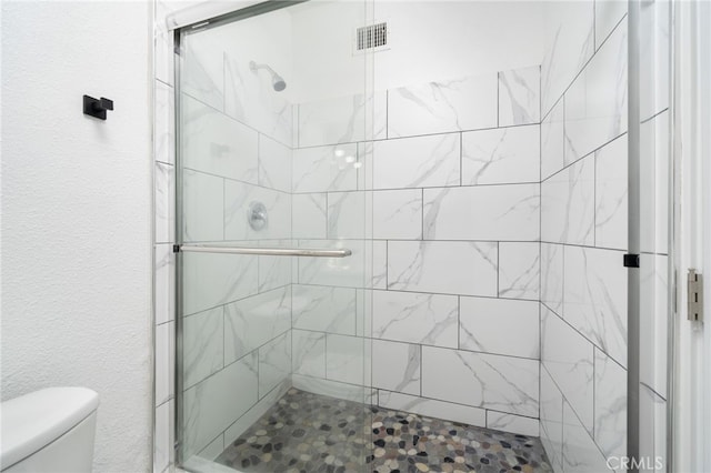 bathroom featuring an enclosed shower and toilet