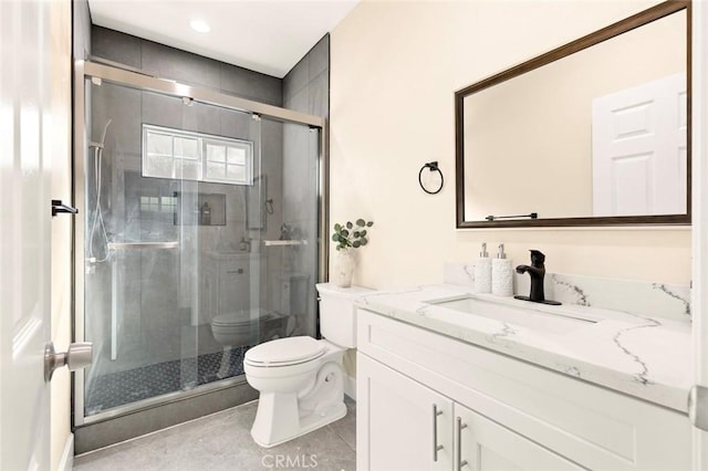 bathroom with vanity, toilet, tile patterned floors, and a shower with shower door