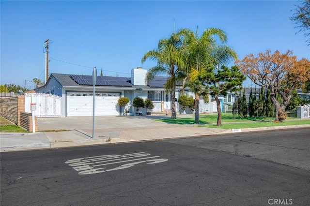 view of front of home featuring a garage and solar panels