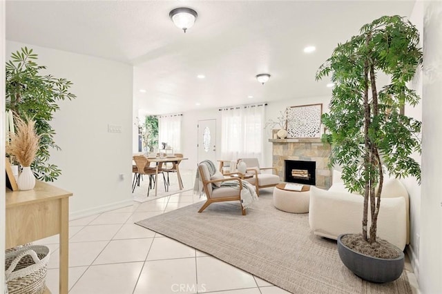 tiled living room with a stone fireplace