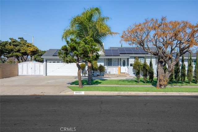 view of front facade featuring a garage and solar panels