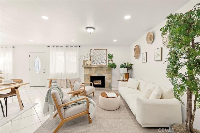 living room with light tile patterned floors and a stone fireplace