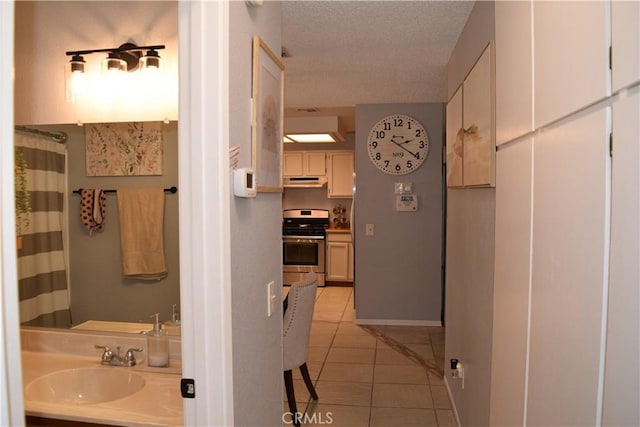 bathroom featuring curtained shower, vanity, a textured ceiling, and tile patterned floors