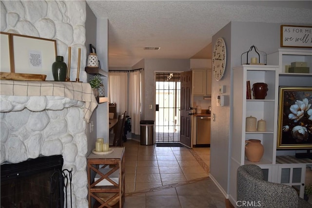 interior space featuring tile patterned flooring, a textured ceiling, and a fireplace