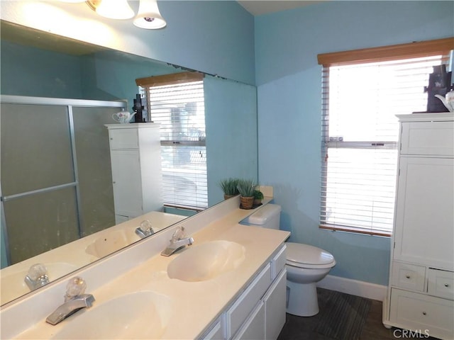 bathroom featuring vanity, an enclosed shower, and toilet