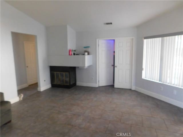 unfurnished living room featuring vaulted ceiling