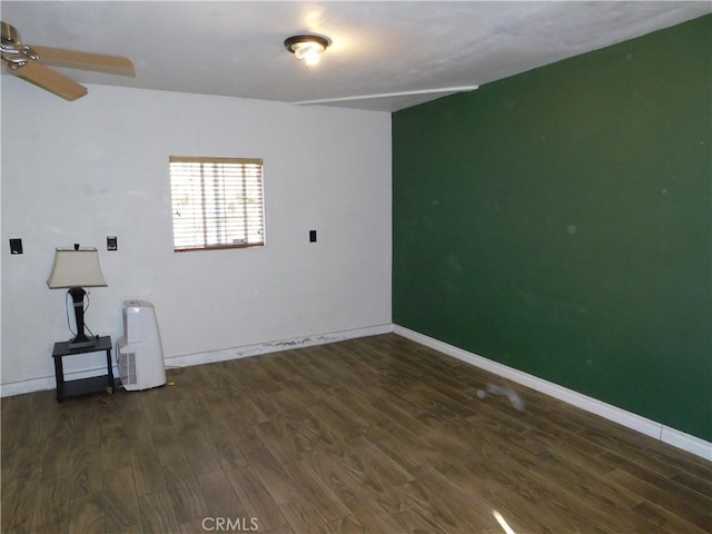 spare room with dark wood-type flooring and ceiling fan