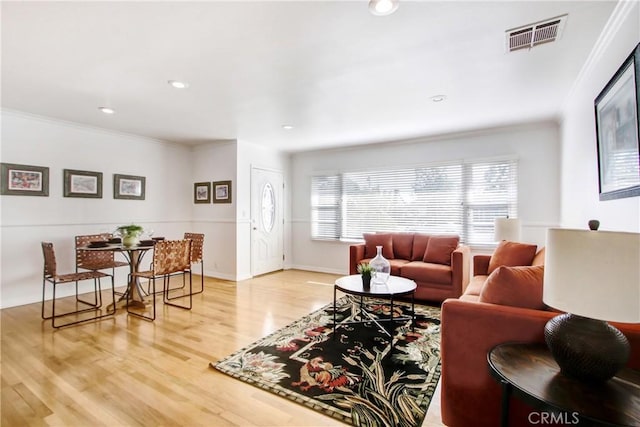 living room with crown molding and hardwood / wood-style floors