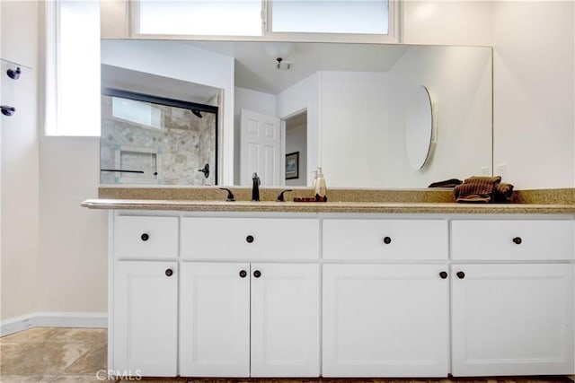 bathroom featuring walk in shower and vanity