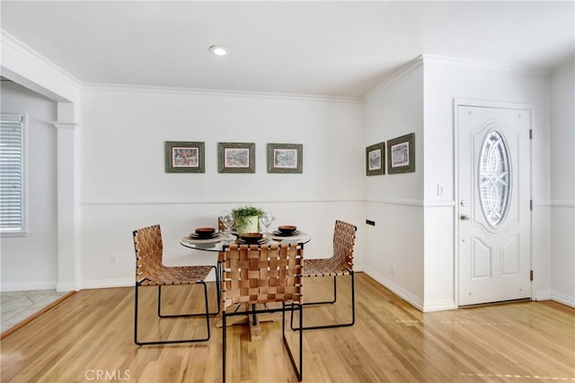 dining space with hardwood / wood-style flooring and ornamental molding