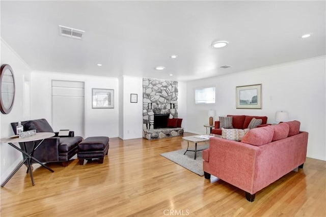 living room with hardwood / wood-style floors, a fireplace, and ornamental molding