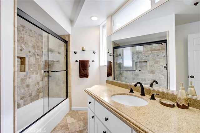 bathroom with vanity, plenty of natural light, and combined bath / shower with glass door