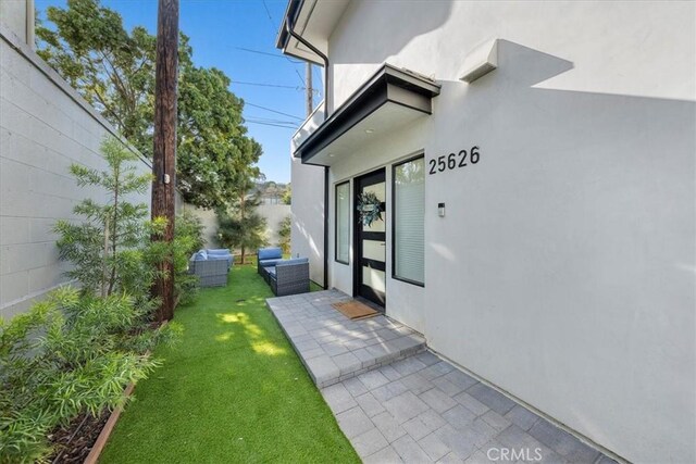 property entrance featuring an outdoor hangout area, a yard, and a patio area