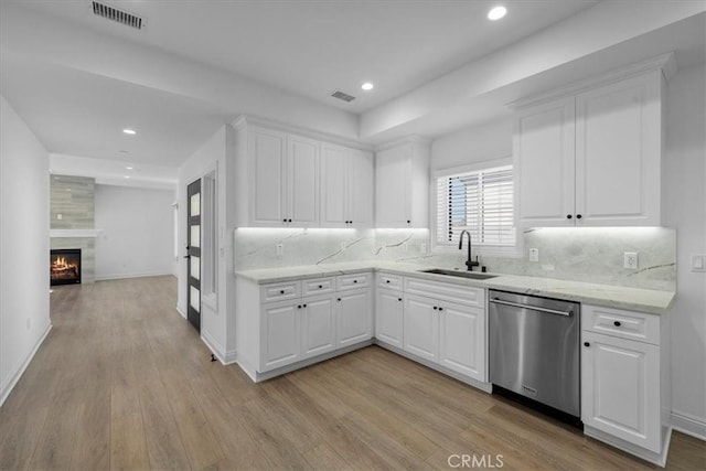 kitchen with white cabinetry, dishwasher, sink, and light hardwood / wood-style flooring