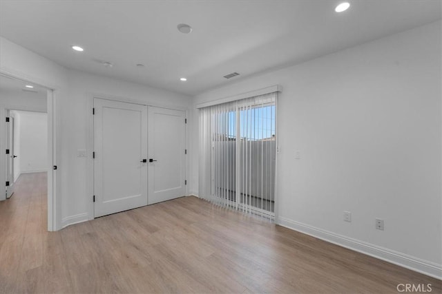 unfurnished bedroom featuring light hardwood / wood-style flooring and a closet