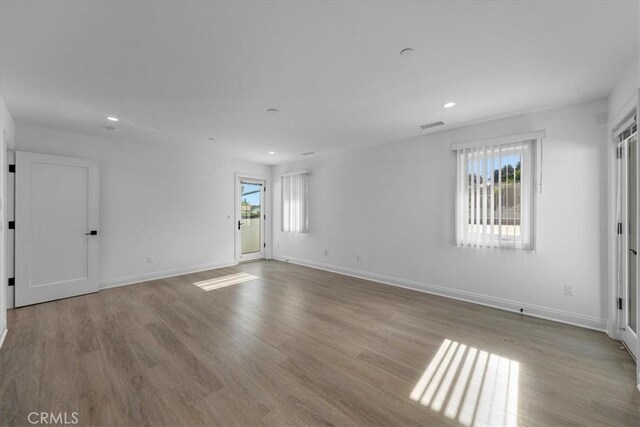 unfurnished room featuring plenty of natural light and light wood-type flooring