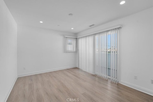 empty room with light hardwood / wood-style flooring