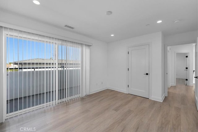 empty room with light hardwood / wood-style flooring