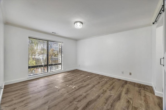 empty room featuring hardwood / wood-style flooring and ornamental molding