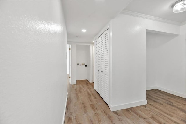 hall with ornamental molding and light wood-type flooring