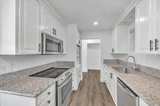 kitchen with white cabinetry, stainless steel appliances, light hardwood / wood-style floors, and sink