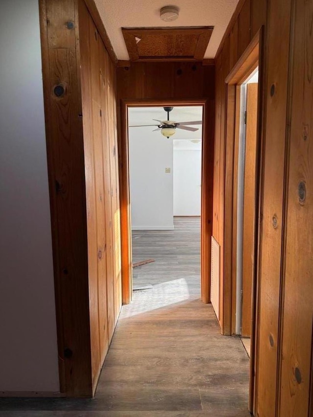 hall featuring light hardwood / wood-style floors and wood walls