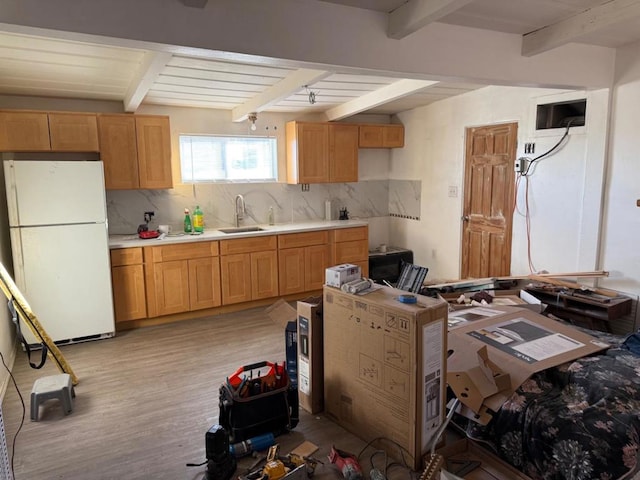 kitchen featuring white fridge, sink, beam ceiling, and decorative backsplash