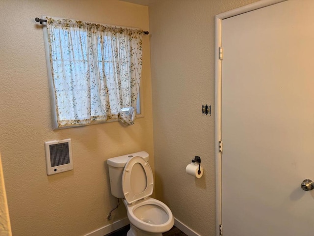 bathroom with toilet and heating unit