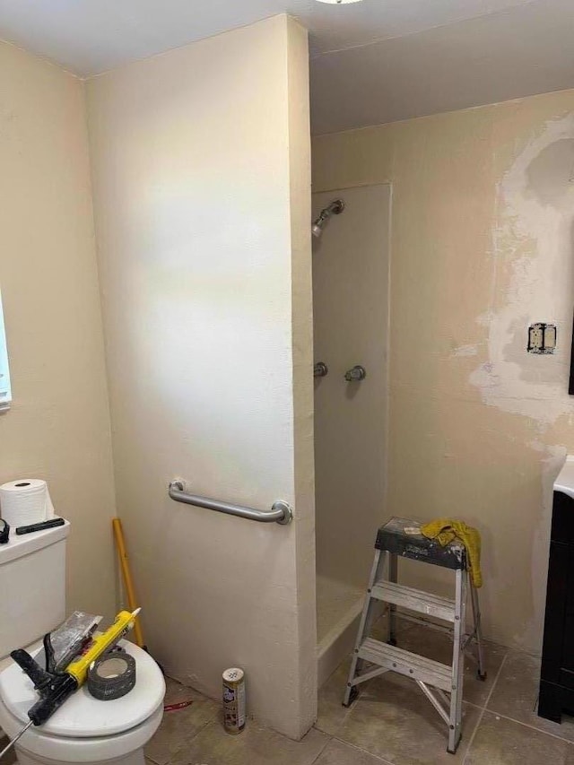 bathroom featuring toilet, tile patterned floors, and walk in shower