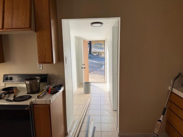 kitchen featuring range with electric stovetop, tile countertops, and light tile patterned floors