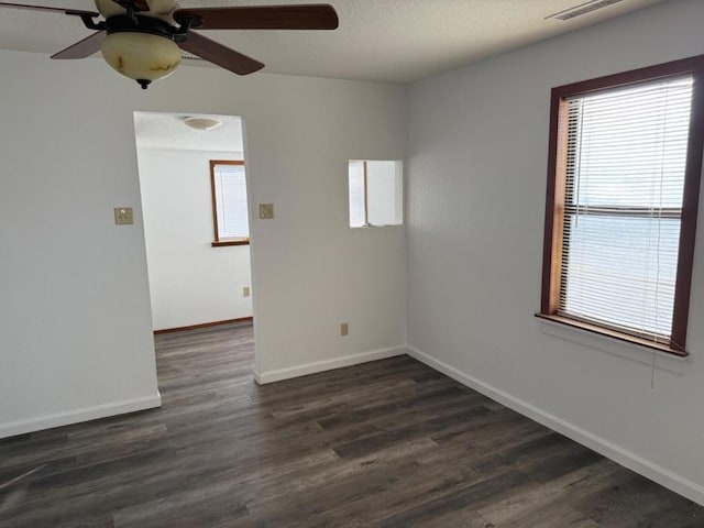 unfurnished room with ceiling fan, dark wood-type flooring, and a textured ceiling