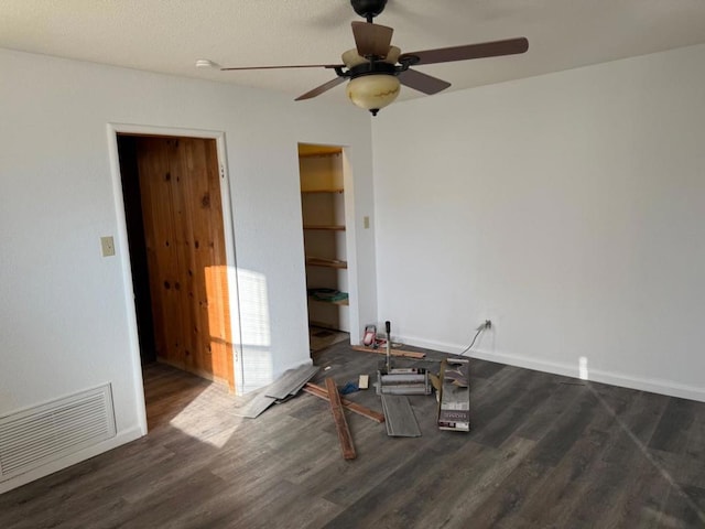 empty room featuring dark hardwood / wood-style flooring and ceiling fan