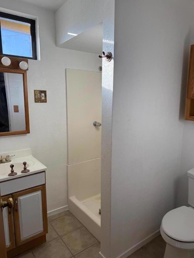 bathroom with walk in shower, tile patterned floors, toilet, and vanity